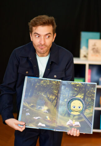 Homme qui tient un livre pour enfant - Agrandir l'image, fenêtre modale