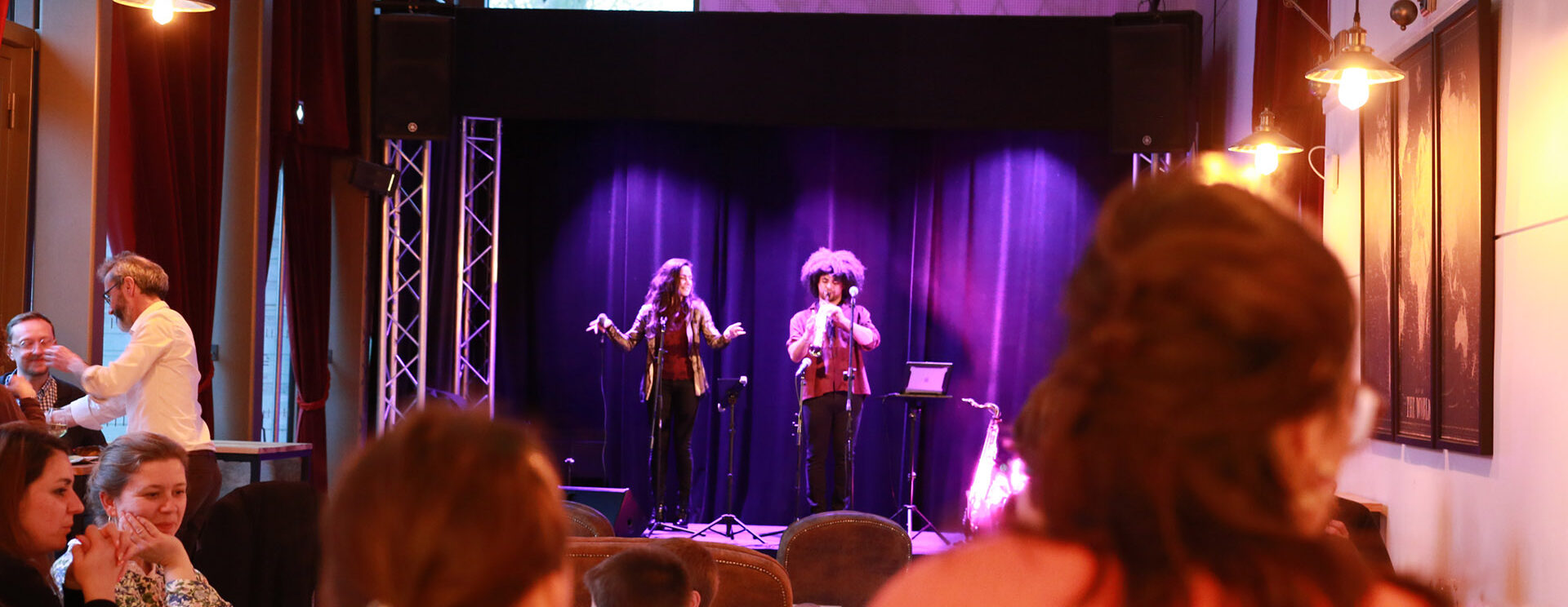 Un groupe joue de la musique sur la scène du bistrot devant le public